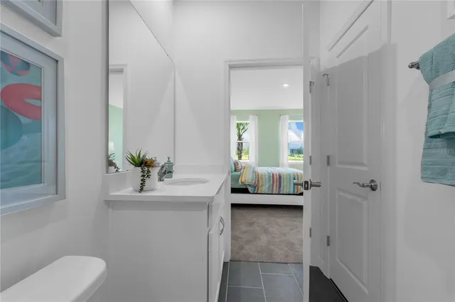 a en suite bathroom with a granite countertop sink and a mirror