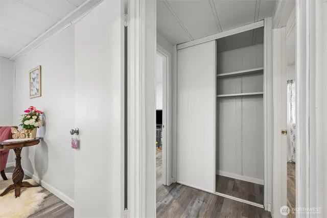 a view of a hallway with wooden floor and closet