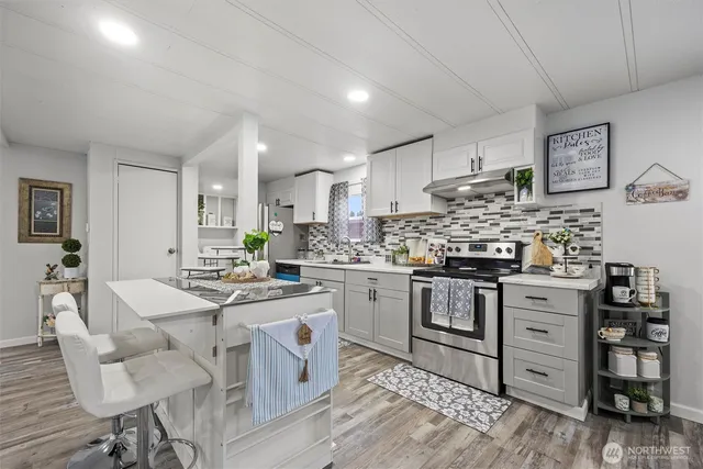 a kitchen with stainless steel appliances kitchen island granite countertop a sink and cabinets
