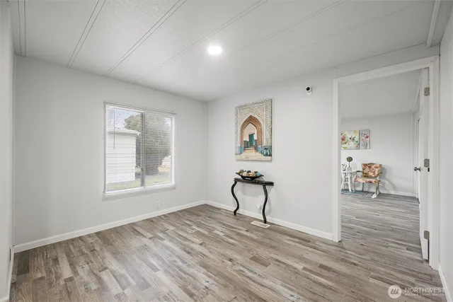 a view of empty room with window and wooden floor