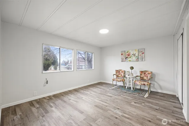 a view of a room with wooden floor lounge chair and windows