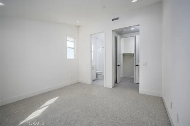 an empty room with closet and windows