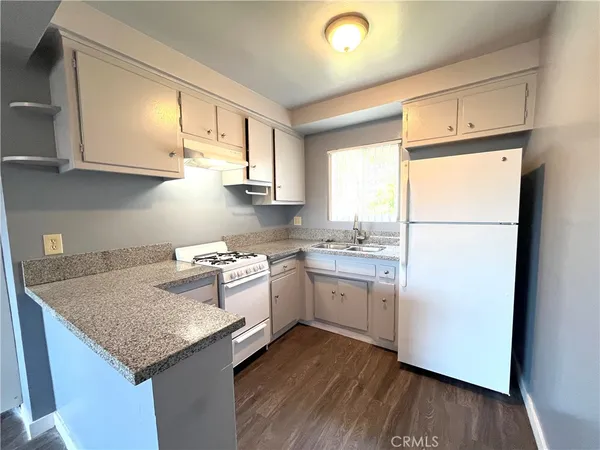 a kitchen with a sink a refrigerator and white cabinets