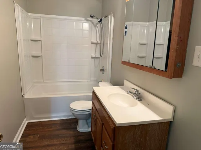 a bathroom with a sink toilet a mirror and shower