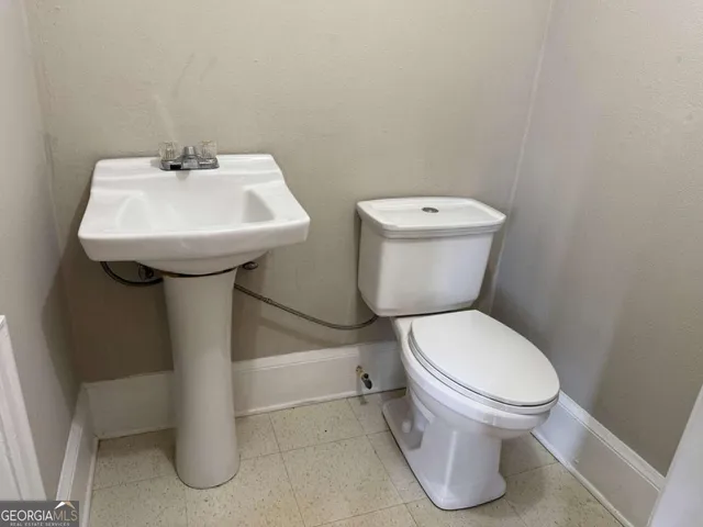 a white toilet sitting next to a white sink