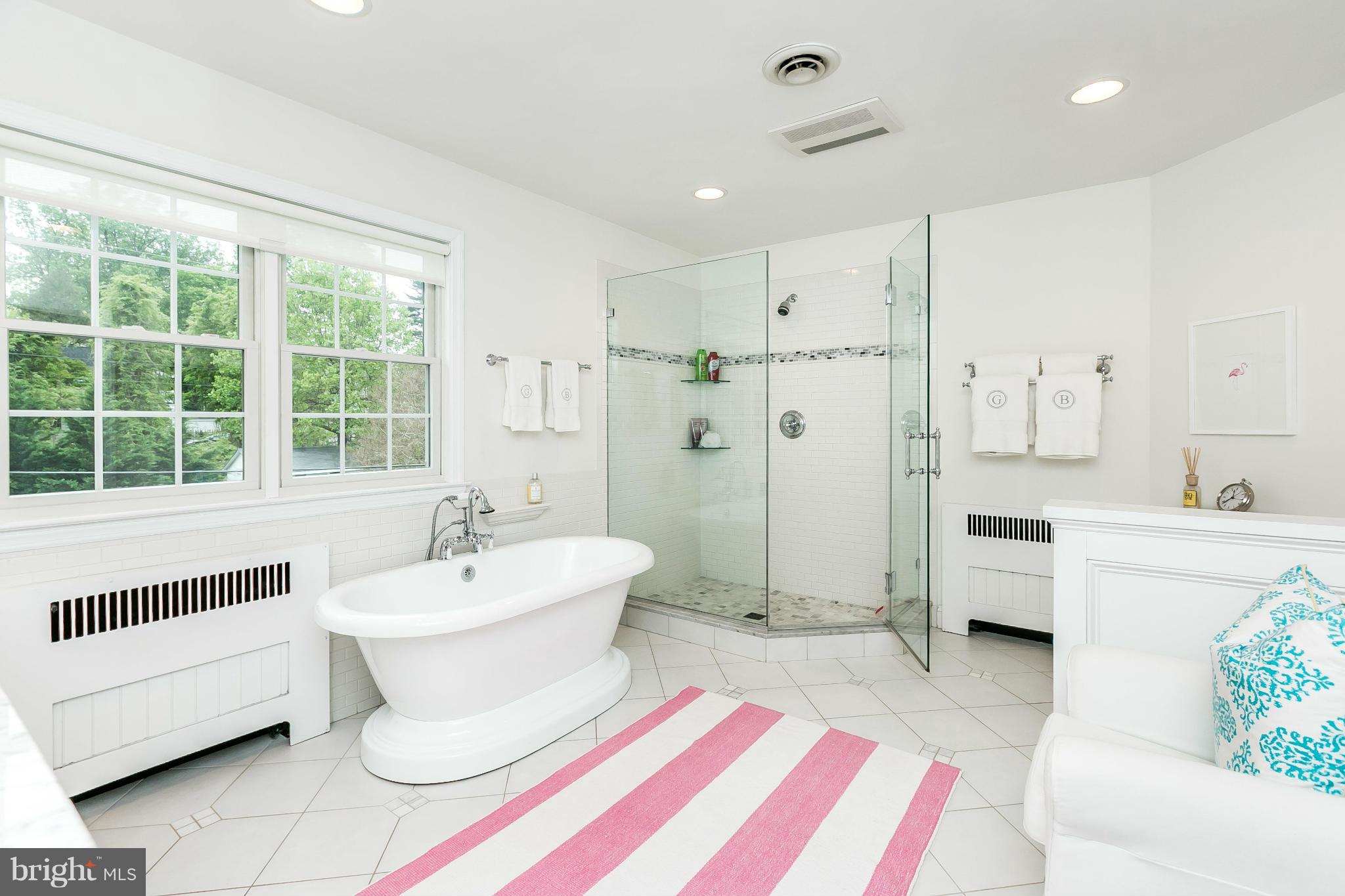 5700 Kenmore Road Baltimore, MD 21210 - Photo 19 of 30 a spacious bathroom with a double vanity sink a mirror and a bathtub