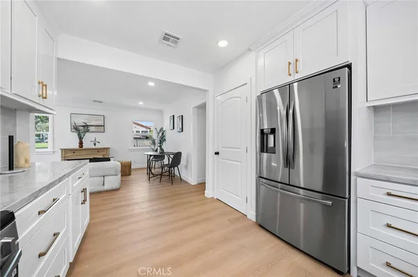 a kitchen with stainless steel appliances a refrigerator and wooden floor