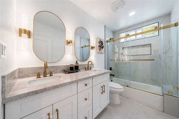 a bathroom with a double vanity sink toilet and shower