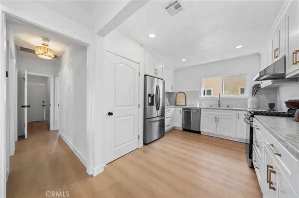 a kitchen with white cabinets and stainless steel appliances