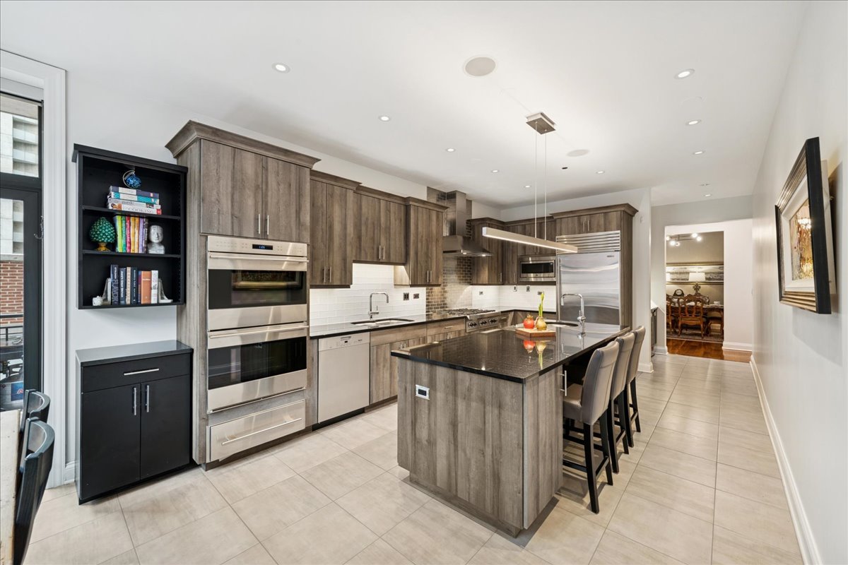 30 West Erie Street, Unit 601 Chicago, IL 60654 - Photo 15 of 30 a kitchen with granite countertop cabinets and steel stainless steel appliances