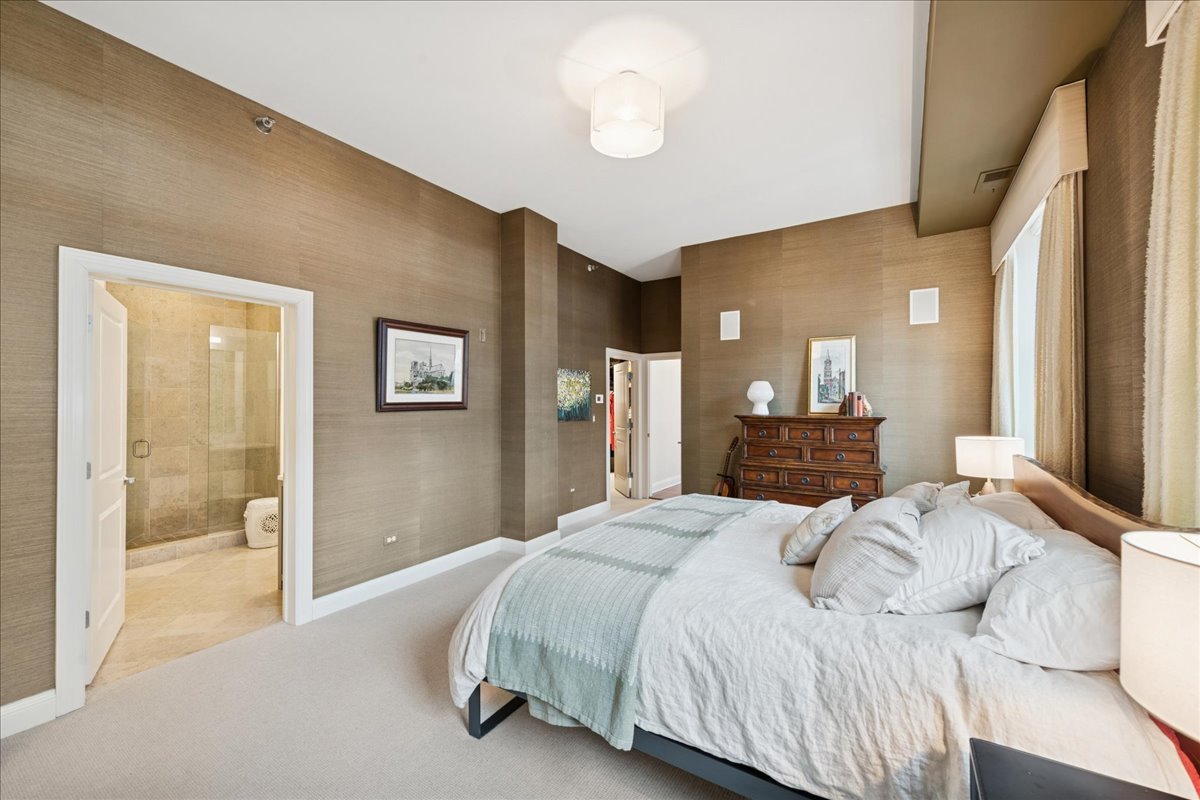 30 West Erie Street, Unit 601 Chicago, IL 60654 - Photo 17 of 30 a spacious bedroom with a bed and a chandelier