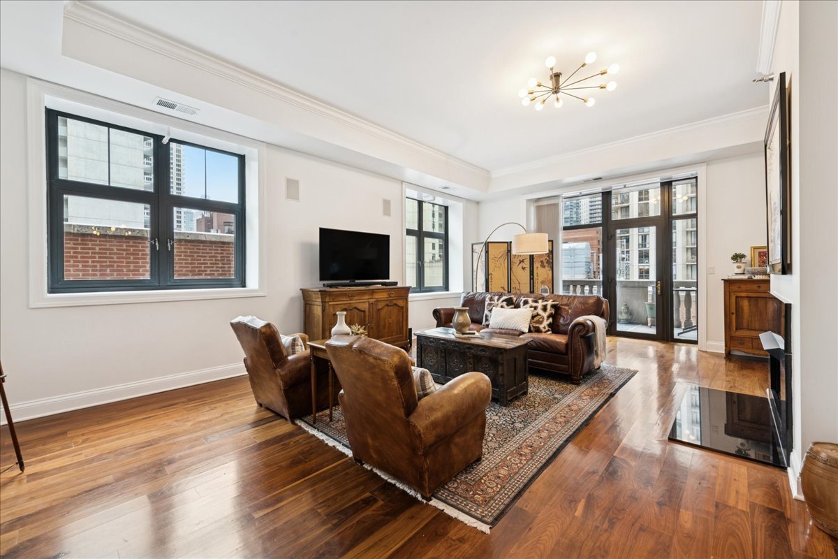 30 West Erie Street, Unit 601 Chicago, IL 60654 - Photo 2 of 30 a living room with furniture fireplace and a flat screen tv