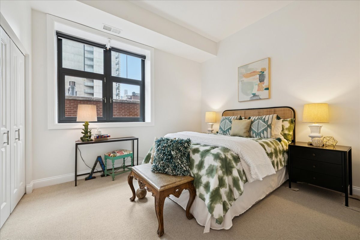 30 West Erie Street, Unit 601 Chicago, IL 60654 - Photo 23 of 30 a bedroom with a bed and a table in it