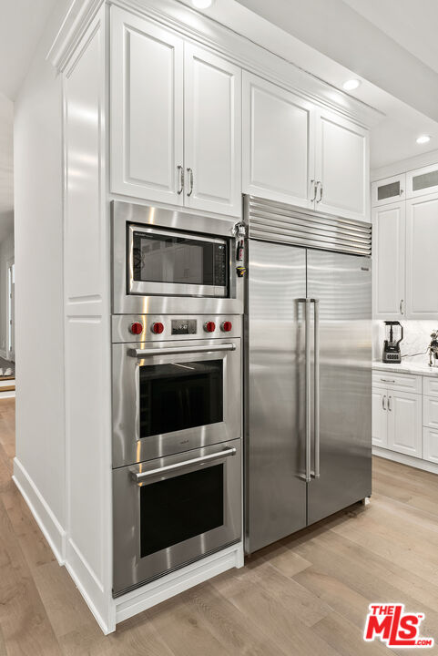 592 30th Street Manhattan Beach, CA 90266 - Photo 19 of 57 a kitchen with white cabinets and stainless steel appliances