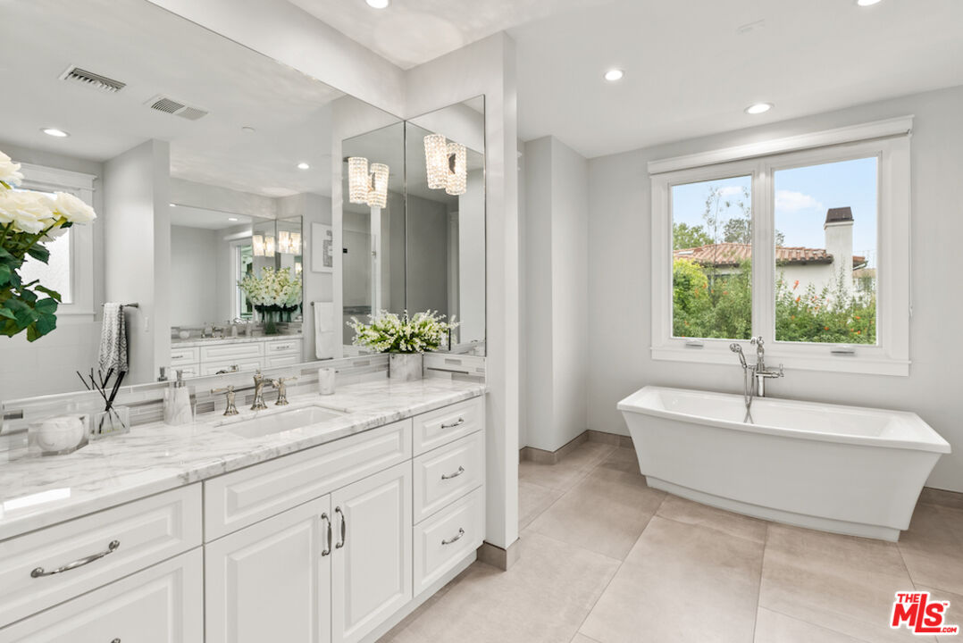592 30th Street Manhattan Beach, CA 90266 - Photo 29 of 57 a spacious bathroom with a double vanity sink large mirror a bathtub and next to a window