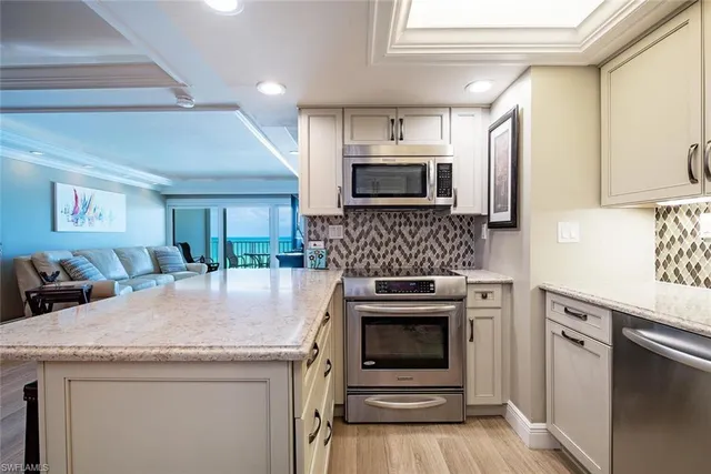 a kitchen with granite countertop a stove sink and microwave