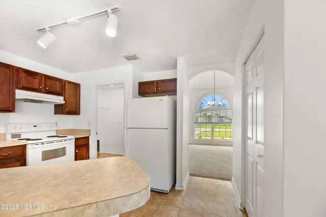 a kitchen with stainless steel appliances granite countertop a refrigerator a oven a sink and a refrigerator