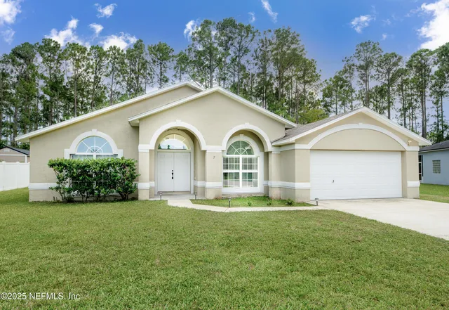 a front view of a house with yard and green space