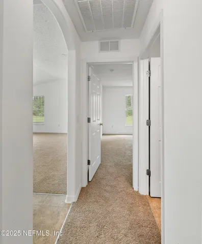 view of a hallway with wooden shelves