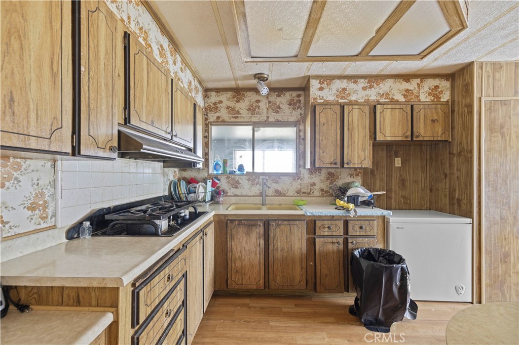 15374 Gaskell Road Rosamond, CA 93560 - Photo 32 of 74 a kitchen with a sink a stove and cabinets