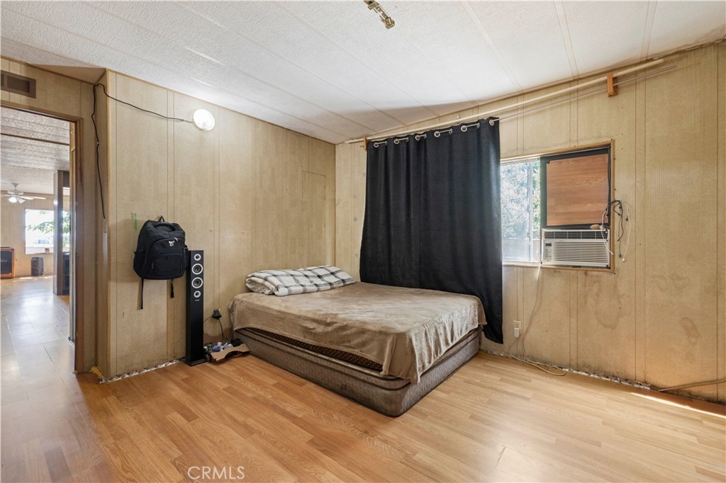 15374 Gaskell Road Rosamond, CA 93560 - Photo 38 of 74 a bedroom with a bed and wooden floor