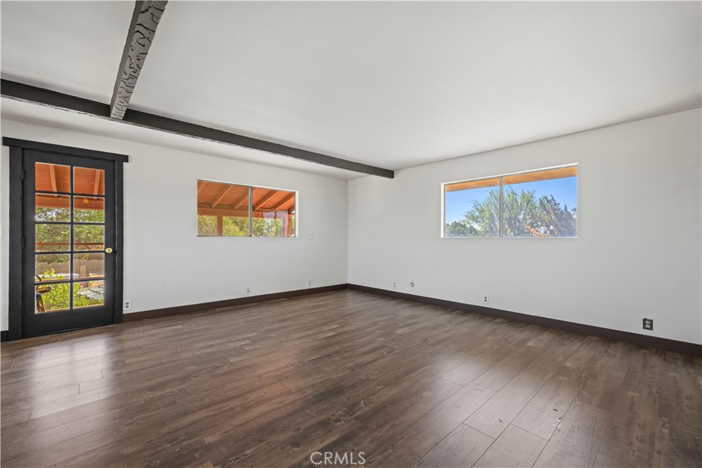 15374 Gaskell Road Rosamond, CA 93560 - Photo 53 of 74 an empty room with wooden floor and windows