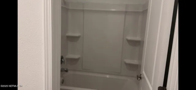 a bathroom with a shower sink and mirror
