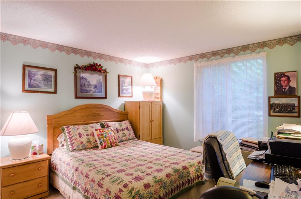 4823 Smokehollow Road Charlotte, NC 28227 - Photo 12 of 19 a bedroom with a bed and a lamp on dresser