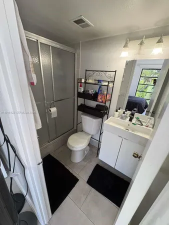 a bathroom with a sink a toilet a mirror and shower