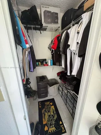 a view of walk in closet with clothes and shoes