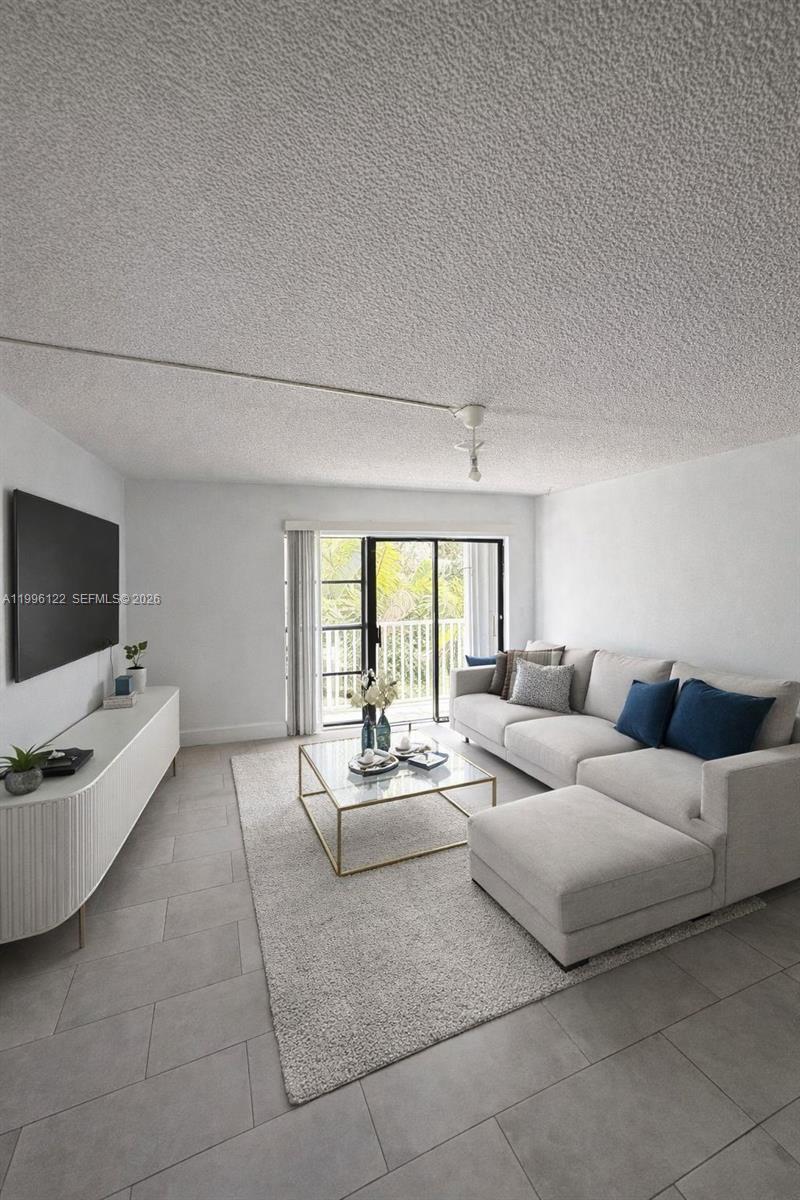 1220 71st Street, Unit 38 Miami Beach, FL 33141 - Photo 3 of 22 a living room with furniture and a flat screen tv