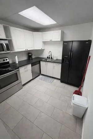 a kitchen with stainless steel appliances a refrigerator sink and cabinets