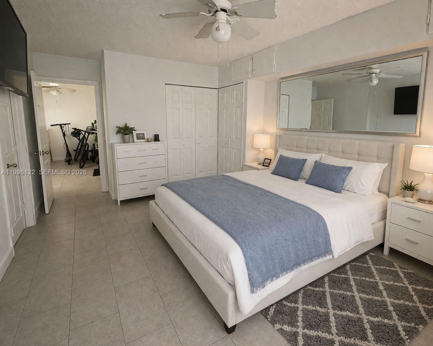 1220 71st Street, Unit 38 Miami Beach, FL 33141 - Photo 8 of 22 a bedroom with a bed and a view of bathroom