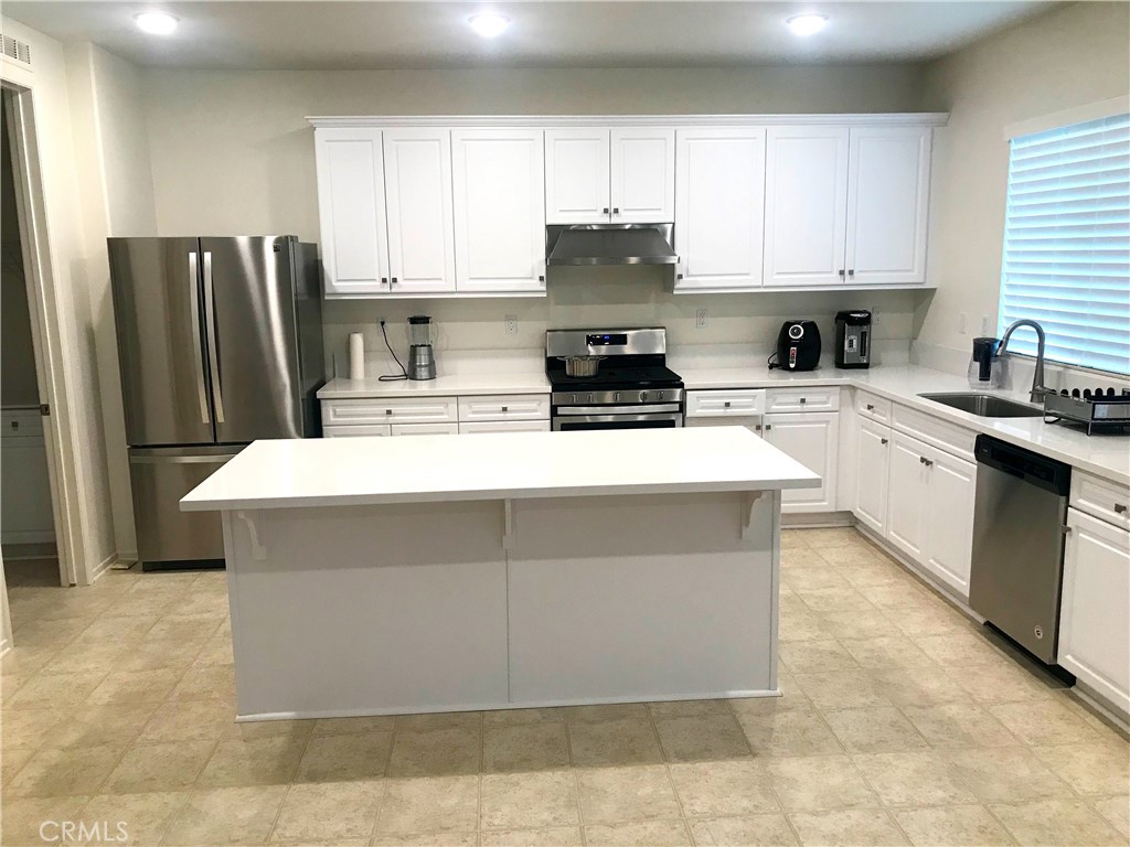 16031 Cordova Road Victorville, CA 92394 - Photo 11 of 34 a kitchen with stainless steel appliances a stove a sink a microwave and cabinets