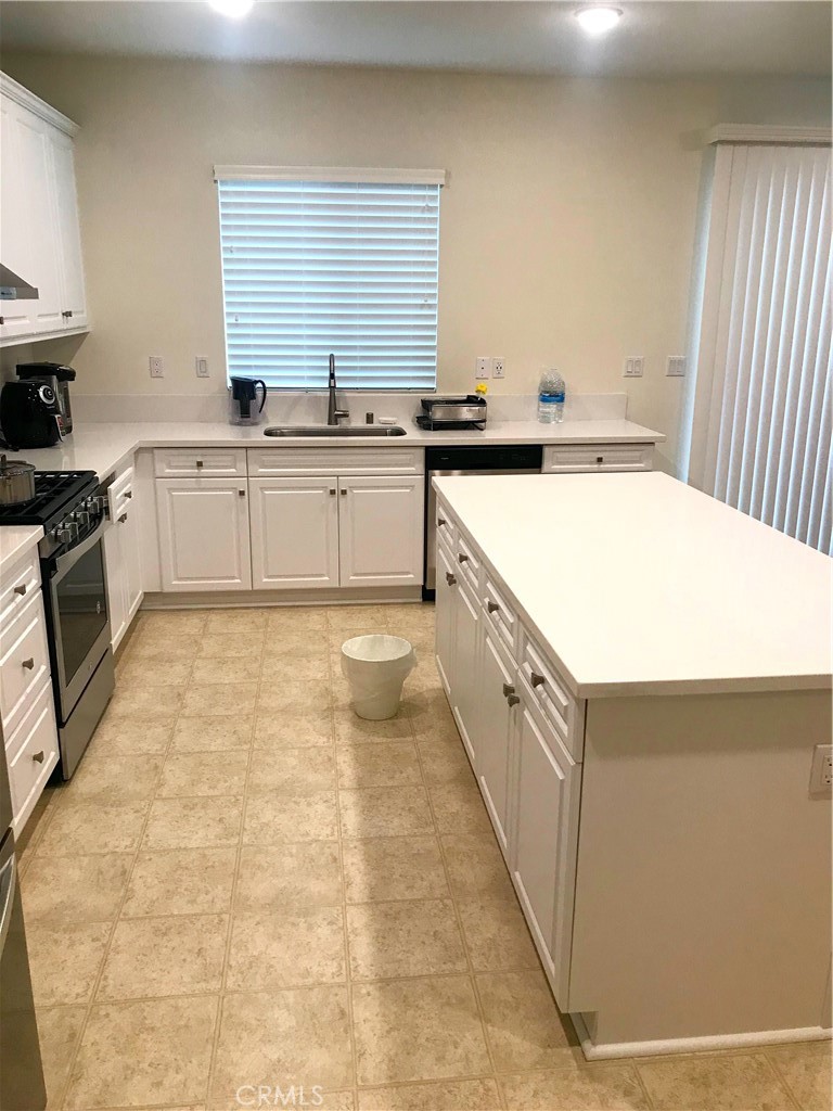 16031 Cordova Road Victorville, CA 92394 - Photo 14 of 34 a kitchen with a sink stove and cabinets