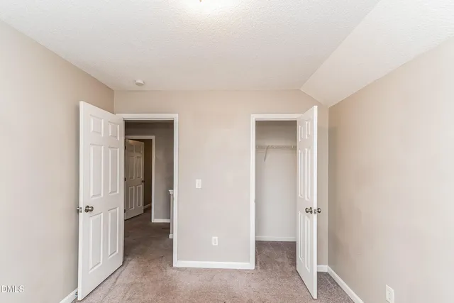 a view of a hallway with closet and wooden floor