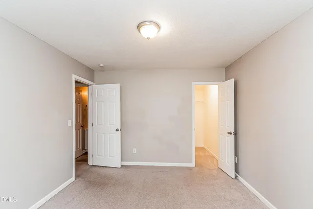 an empty room with closet and mirror