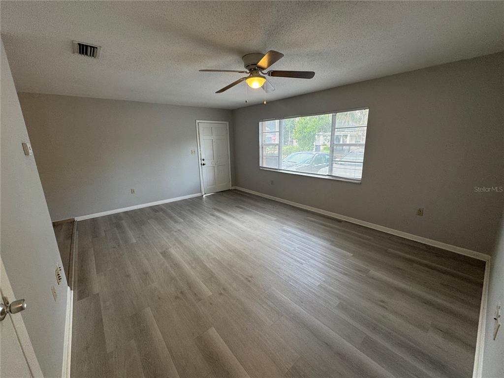 1610 High Street Leesburg, FL 34748 - Photo 2 of 11 an empty room with wooden floor and windows