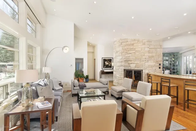 a living room with fireplace furniture and a large window