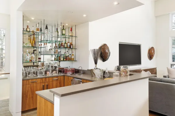 a dining room with furniture wooden floor and a kitchen view
