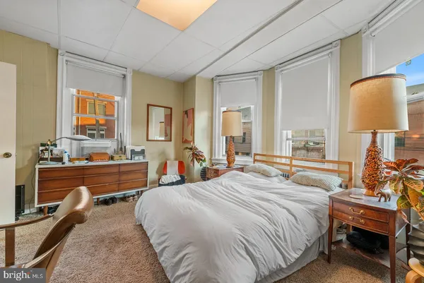 a bedroom with a bed and dresser with mirror