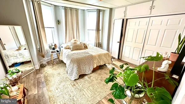 a bedroom with a bed a dresser and a window