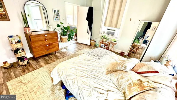 a bedroom with a bed and a mirror on the dresser