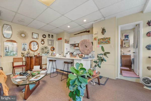 a living room with furniture and clock on the wall