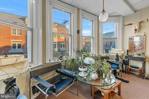 a living room with furniture a flat screen tv and a large window