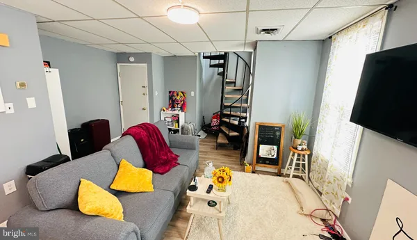 a living room with furniture gym equipment and a flat screen tv