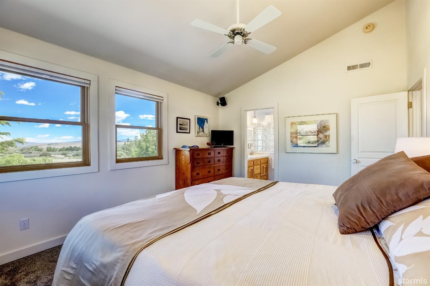 604 River Ranch Road Woodfords, CA 96120 - Photo 13 of 25 a bedroom with a large bed a flat tv screen and large window