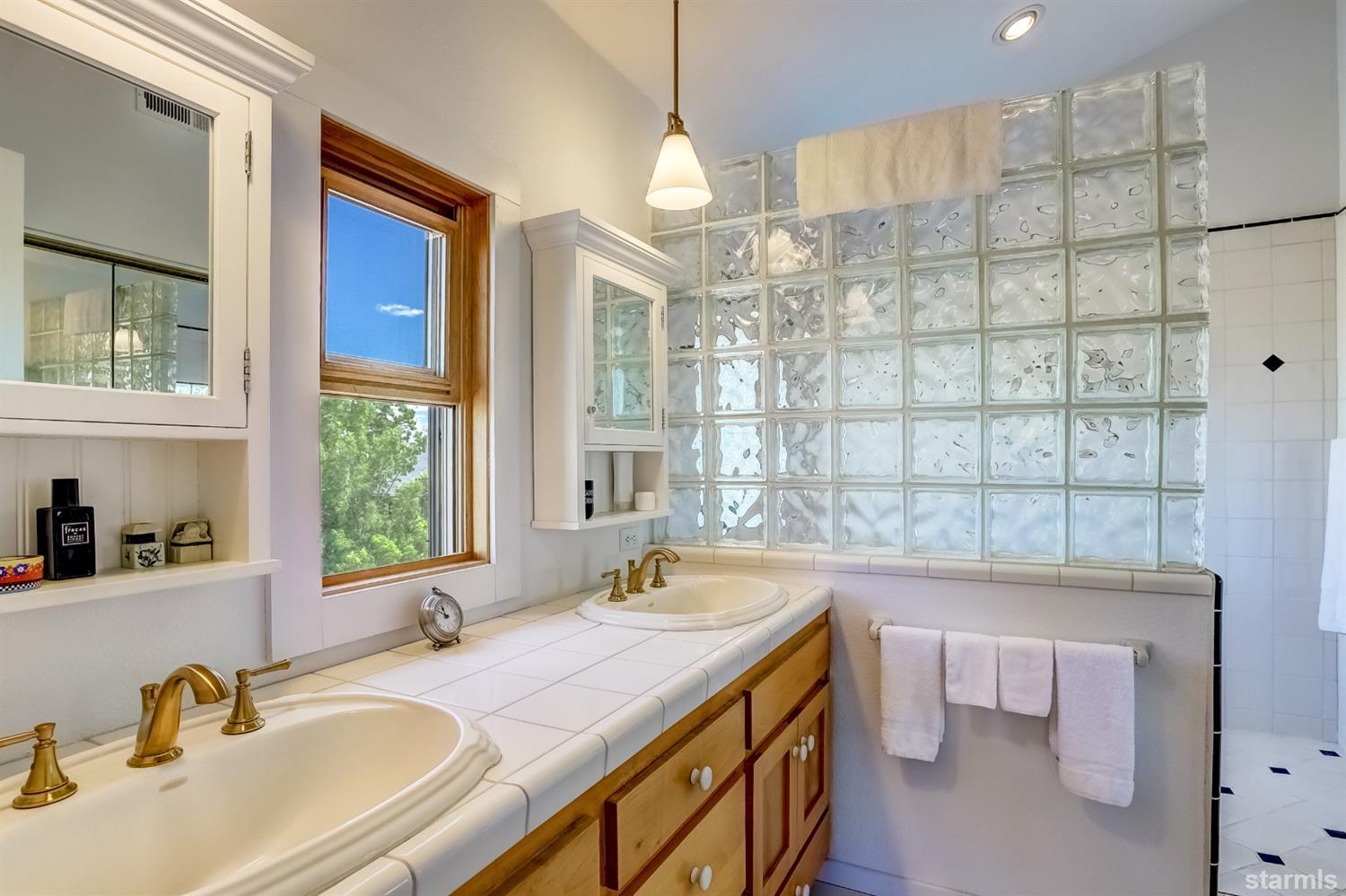 604 River Ranch Road Woodfords, CA 96120 - Photo 14 of 25 a bathroom with a granite countertop sink a large mirror and a bathtub next to a window