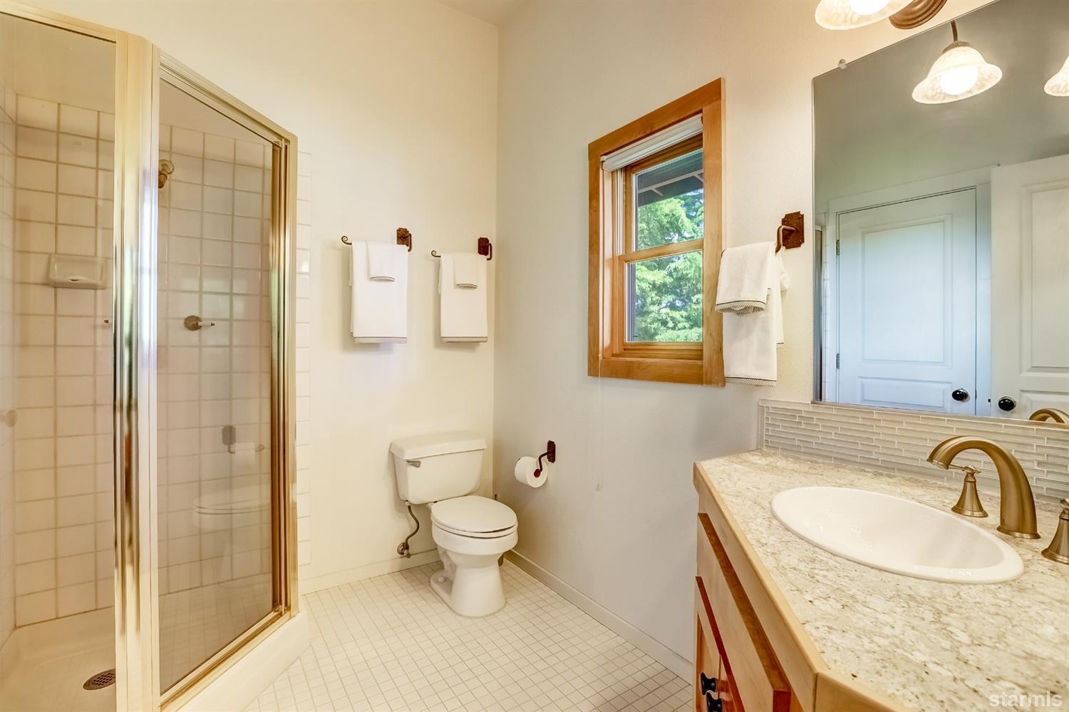 604 River Ranch Road Woodfords, CA 96120 - Photo 20 of 25 a bathroom with a granite countertop sink a toilet a mirror and shower