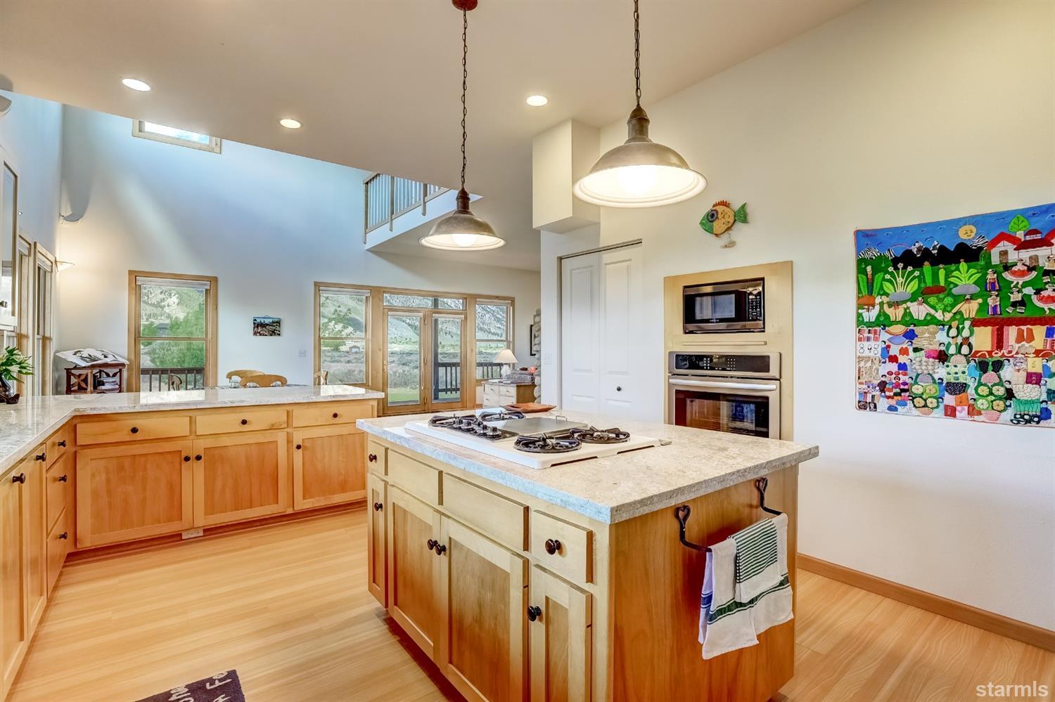 604 River Ranch Road Woodfords, CA 96120 - Photo 6 of 25 a kitchen with stainless steel appliances granite countertop a stove a sink a center island and a wooden floor